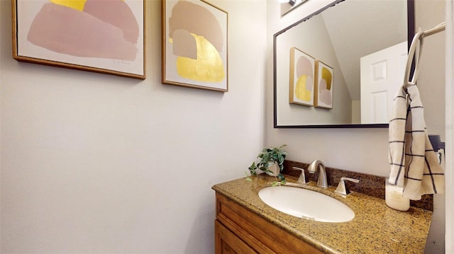 bathroom with vanity and lofted ceiling