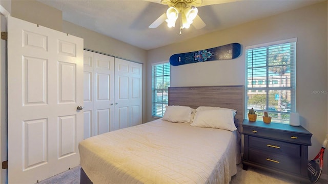 carpeted bedroom with multiple windows, a closet, and ceiling fan