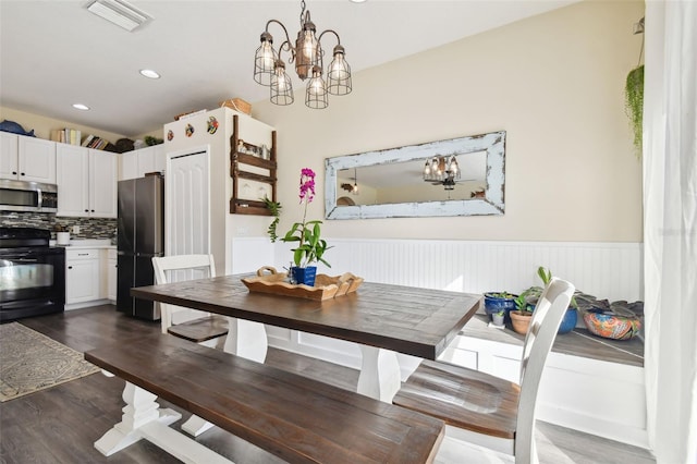 dining space with a chandelier and dark hardwood / wood-style floors