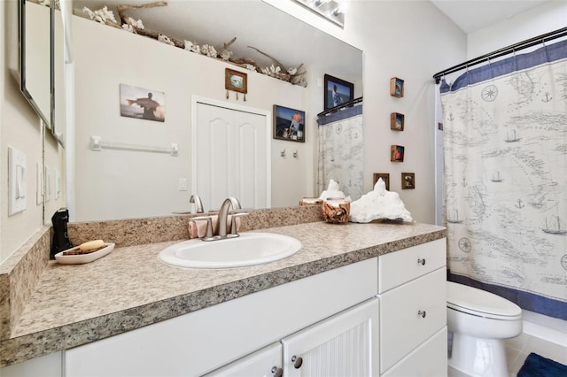 bathroom featuring tile patterned flooring, curtained shower, vanity, and toilet