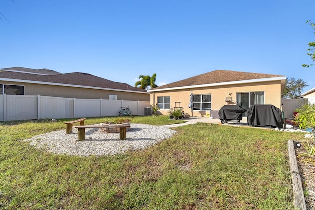 back of property featuring a patio area, a yard, and an outdoor fire pit