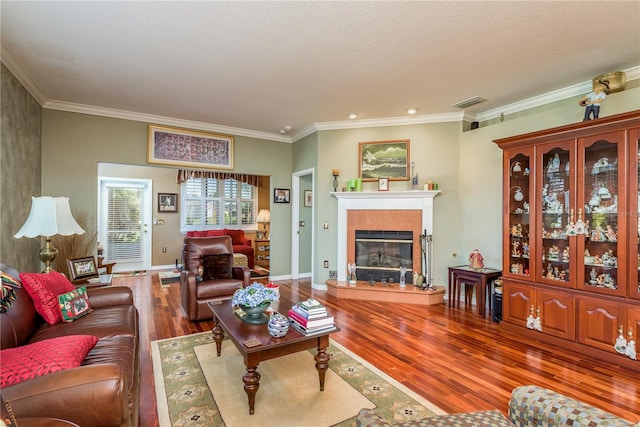 living room with hardwood / wood-style flooring, ornamental molding, and a textured ceiling