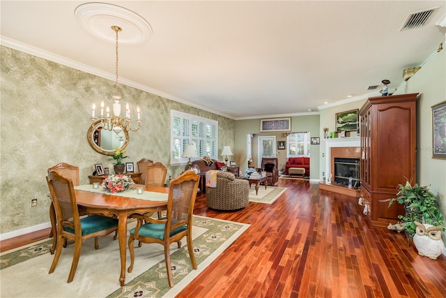 dining room featuring a notable chandelier, ornamental molding, and dark wood-type flooring