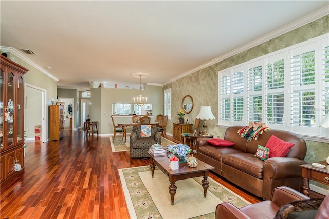 living room featuring a notable chandelier, ornamental molding, a healthy amount of sunlight, and dark hardwood / wood-style flooring