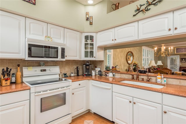 kitchen with white cabinets, sink, and white appliances