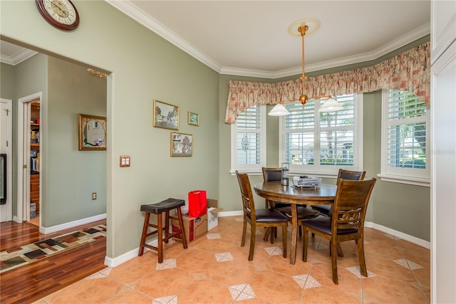 dining room featuring crown molding, light hardwood / wood-style flooring, and a healthy amount of sunlight