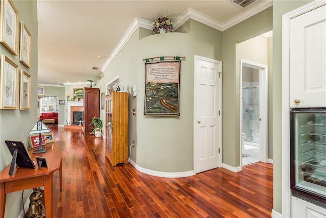 corridor featuring dark wood-type flooring, crown molding, and wine cooler