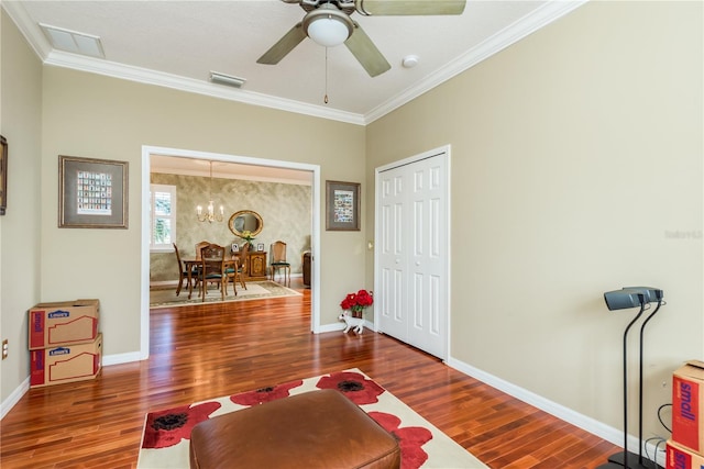 sitting room with crown molding, dark hardwood / wood-style flooring, and ceiling fan with notable chandelier