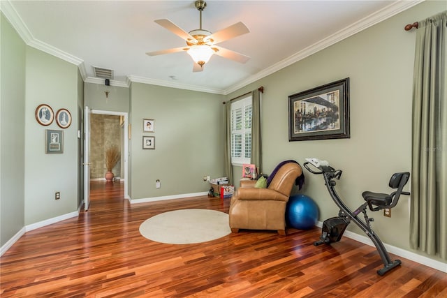 living area with ornamental molding, wood-type flooring, and ceiling fan