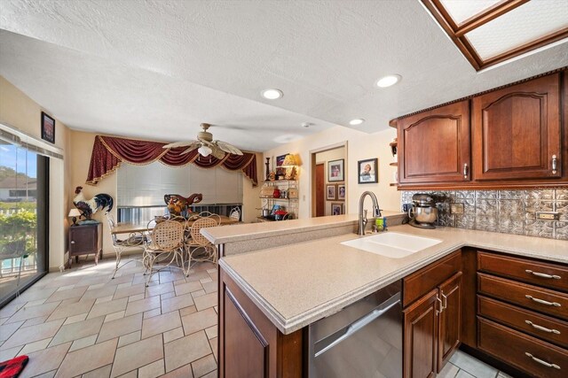 kitchen featuring sink, backsplash, dishwasher, and kitchen peninsula