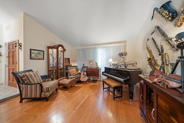 living area featuring lofted ceiling and hardwood / wood-style floors