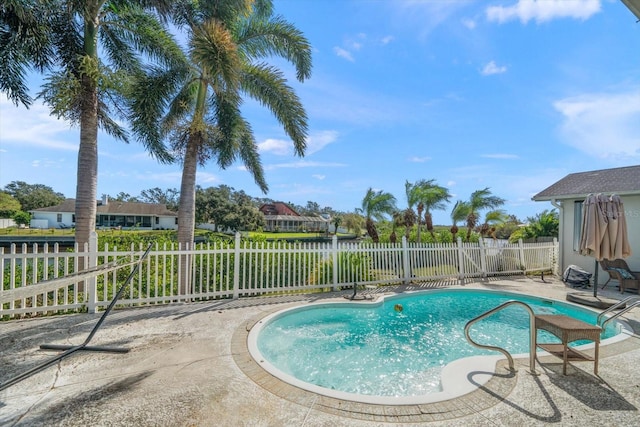 view of pool with a water view and a patio