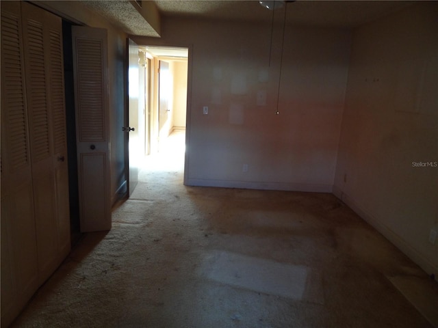 empty room featuring a textured ceiling and light carpet