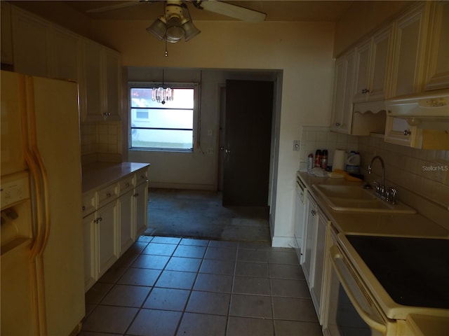 kitchen featuring backsplash, light tile patterned flooring, white appliances, and sink