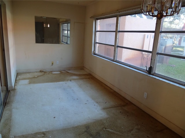 unfurnished room featuring a chandelier and a healthy amount of sunlight