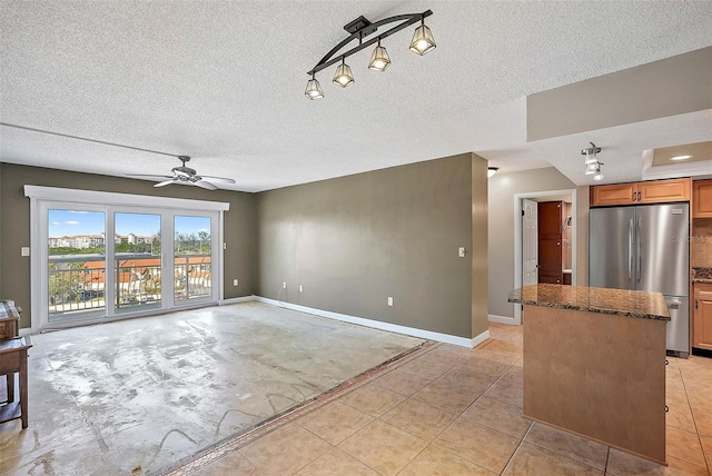 tiled living room featuring a textured ceiling and ceiling fan