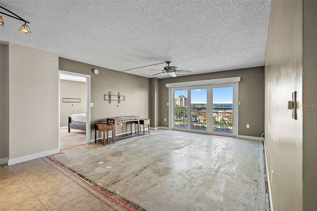 empty room with a textured ceiling and ceiling fan