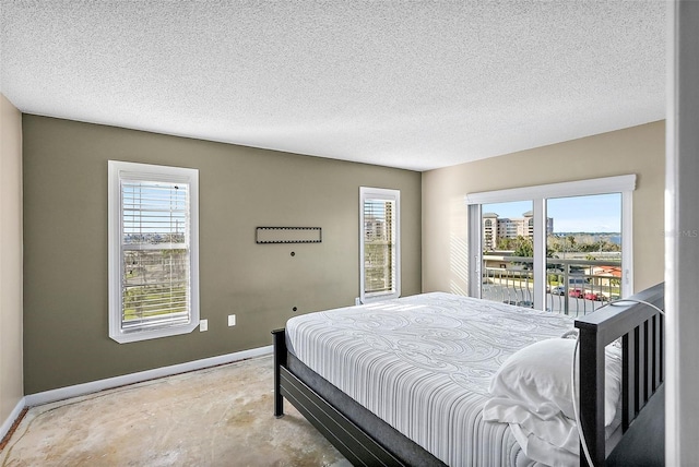 bedroom with access to outside and a textured ceiling