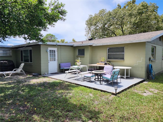 rear view of house with a patio and a lawn