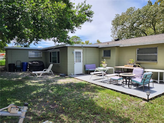 rear view of property featuring a patio, cooling unit, and a lawn