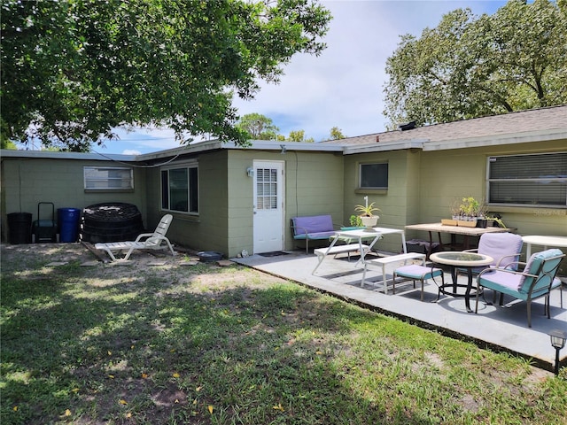 rear view of property with a patio and a lawn