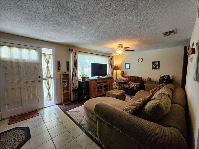 tiled living room featuring a textured ceiling and ceiling fan