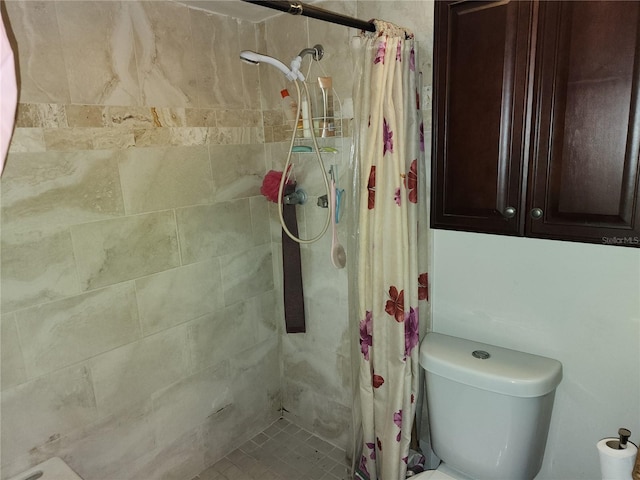 bathroom featuring curtained shower and toilet