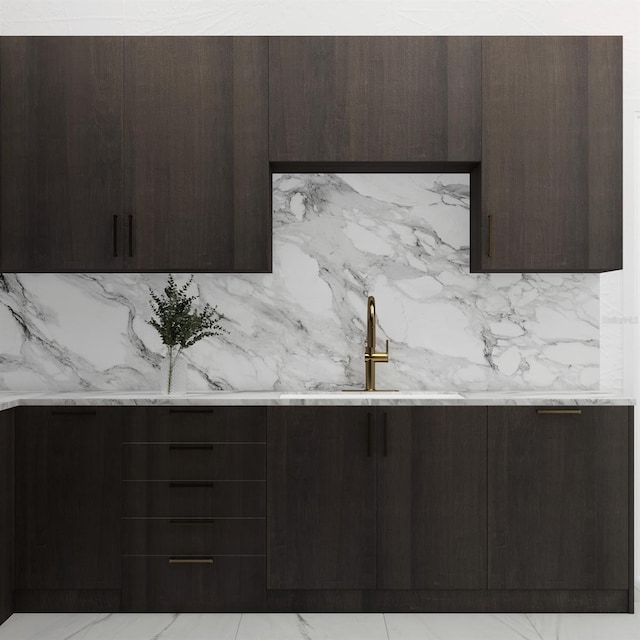 kitchen featuring sink, dark brown cabinets, and light stone countertops