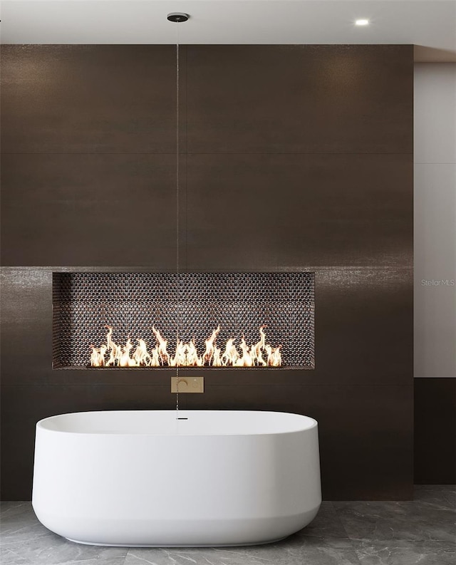 bathroom featuring tile walls and a tub to relax in