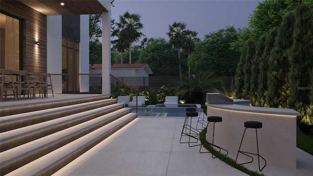 patio terrace at dusk with pool water feature and exterior bar