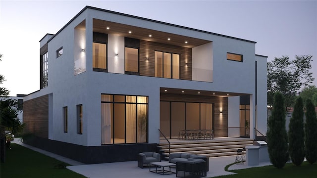 back house at dusk with a patio area and an outdoor hangout area