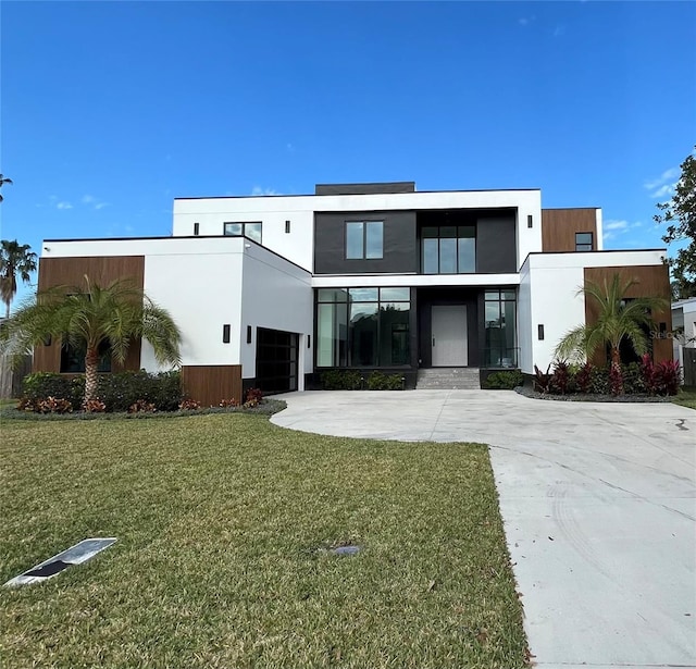 rear view of house featuring a lawn and a garage