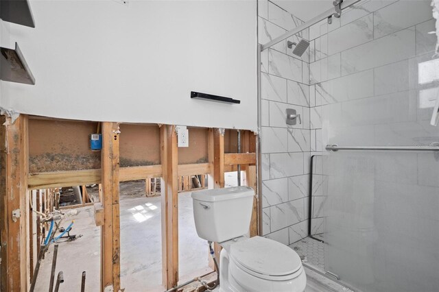 bathroom with a shower with door and toilet