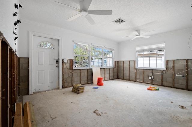 foyer entrance featuring crown molding, a textured ceiling, and a wealth of natural light