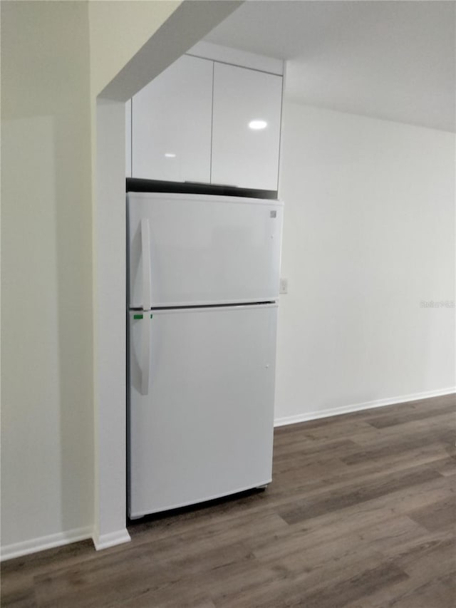 details with white fridge and wood-type flooring