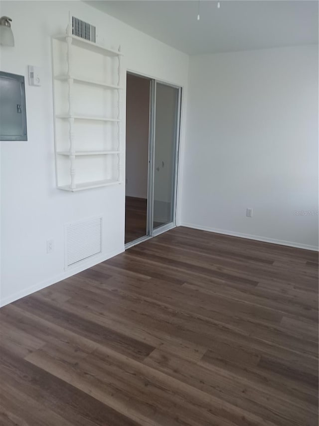 unfurnished bedroom featuring electric panel, a closet, and dark hardwood / wood-style flooring