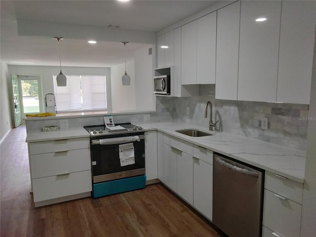 kitchen featuring stainless steel appliances, pendant lighting, dark hardwood / wood-style floors, and white cabinets