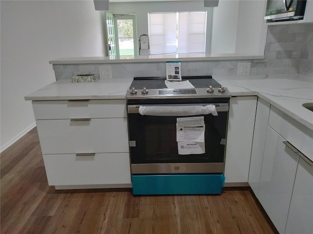 kitchen with stainless steel appliances, dark hardwood / wood-style flooring, and white cabinets