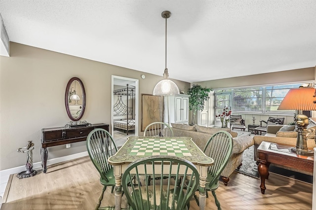 dining space featuring light hardwood / wood-style floors and a textured ceiling