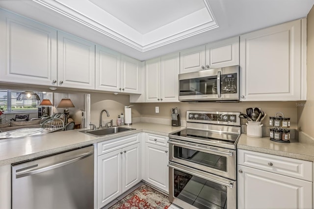 kitchen with appliances with stainless steel finishes, white cabinetry, and sink