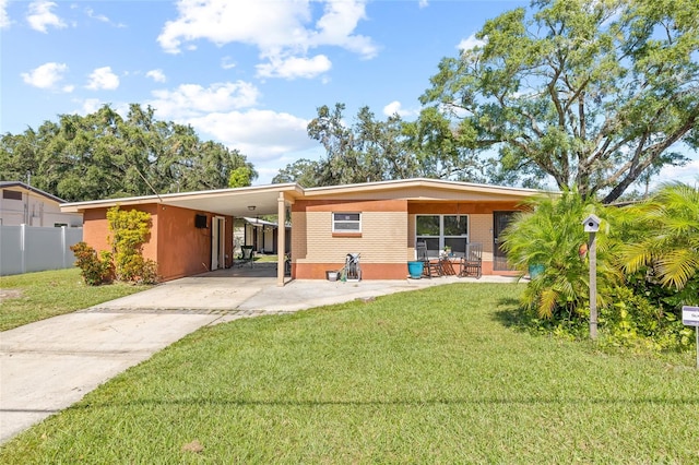 rear view of property with a lawn and a carport