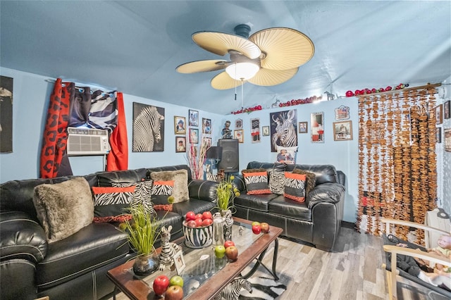 living room with a wall mounted air conditioner, light wood-type flooring, and ceiling fan