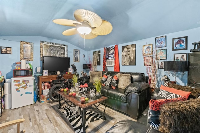 living room featuring vaulted ceiling, light hardwood / wood-style flooring, and ceiling fan