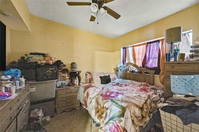 bedroom with ceiling fan, carpet flooring, and a textured ceiling