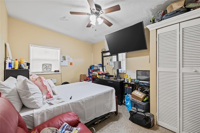 bedroom featuring a closet, a textured ceiling, carpet, and ceiling fan