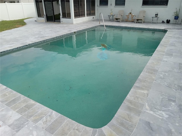 view of pool with a patio area and a sunroom