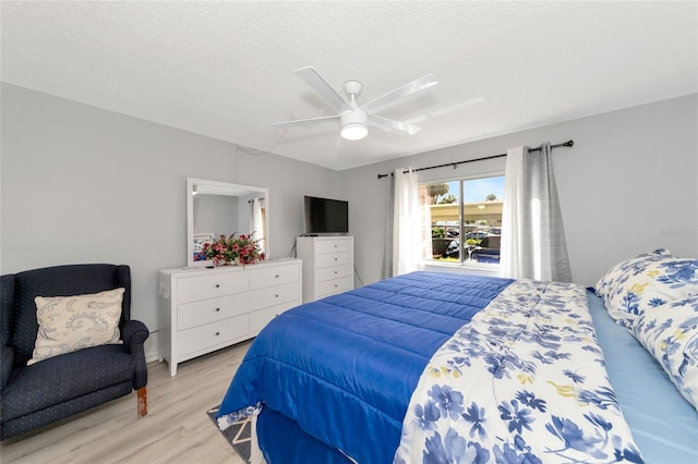 bedroom with a textured ceiling, light hardwood / wood-style flooring, and ceiling fan