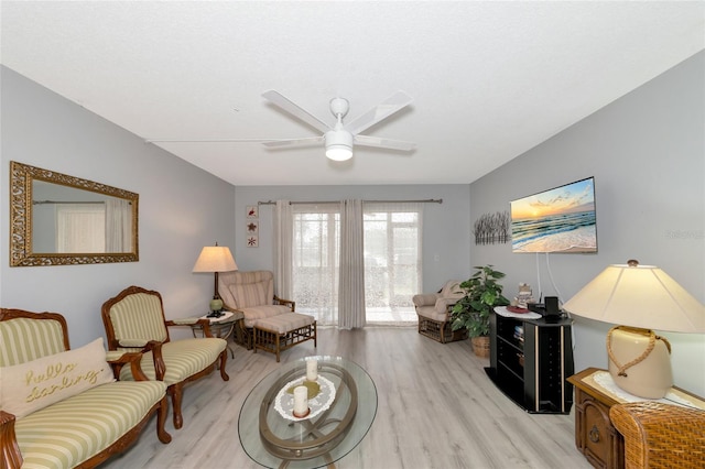 living area with ceiling fan and light hardwood / wood-style floors