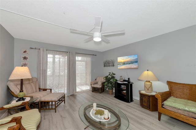 sitting room with ceiling fan, light hardwood / wood-style flooring, and a textured ceiling