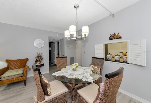 dining area featuring light hardwood / wood-style floors and a notable chandelier